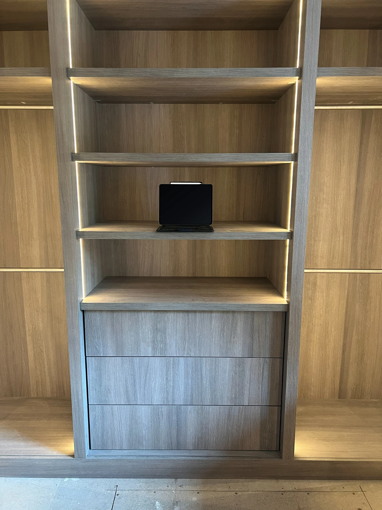 Front view of the installed central drawer bank and illuminated shelving
