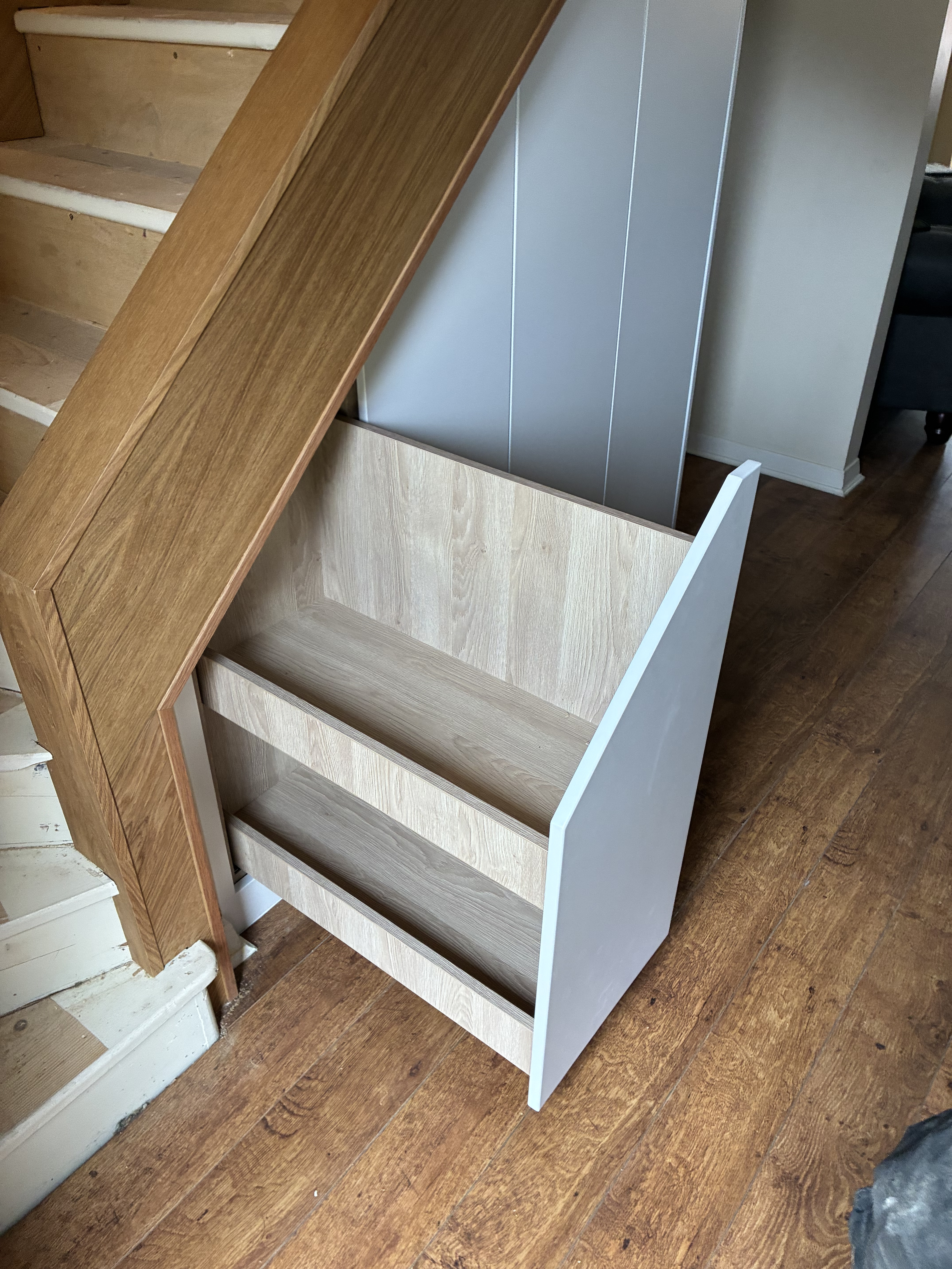 Client-supplied site photograph of the fitted two-tier pull-out open beneath the existing timber staircase.